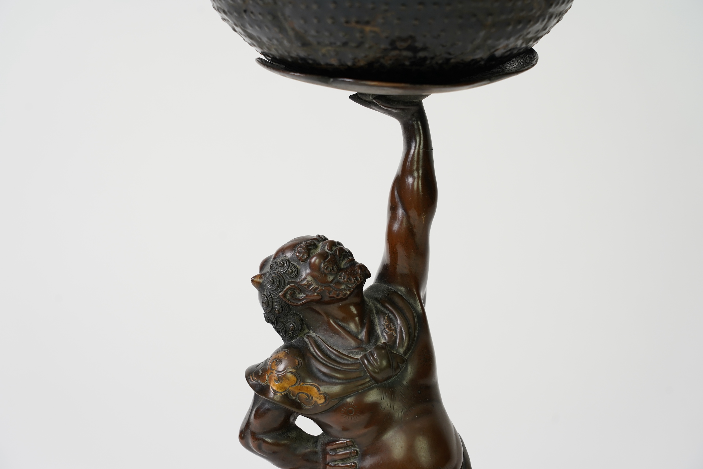 A Japanese bronze figure of an Oni holding a temple bell aloft, Meiji period, in Miyao style